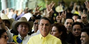 Jair Bolsonaro umgeben von Anhängern, die mit ihren Händen das Victors-Zeichen formen
