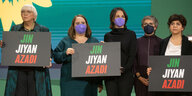 Gruene Frauen halten Solidaritätsplakate hoch "Jin Jihan Azadi"
