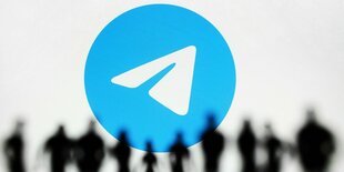 Das Telegram-Logo vor einer Reihe von Menschen, die als Silhouette erkennbar sind