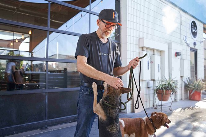 Bill spielt auf der Terrasse seines Häuschens mit seinen zwei Hunden