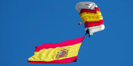 Das Foto zeigt einen Fallschirmspringer mit einer großen spanischen Flagge.