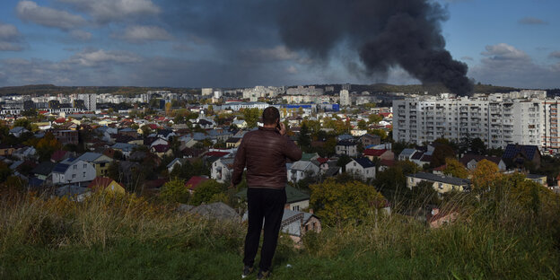 Ein Mann beobachtet, wie Rauchwolken über Lviv aufsteigen