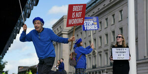 Regierungskritische Demonstranten tragen Plakate vor der Jahreskonferenz der Tories und tanzen auf der Straße