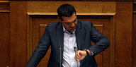 Tsipras schaut auf seine Armbanduhr