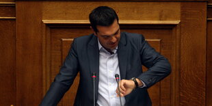 Tsipras schaut auf seine Armbanduhr