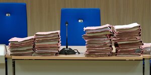 Mehrere Stapel Gerichtsakten auf einem Tisch bei Gericht; das Landesarbeitsgericht Bremen hat einer Betriebsrätin in ihrer Mobbingklage gegen den Arbeitgeber recht gegeben