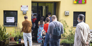 Menschen stehen in der Schlange vor einem Wahllokal