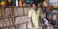 Joseph Ousmane Togbe steht vor einem Regal voller Vinyl Schallplatten