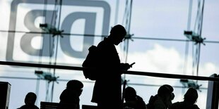 Eine Person schaut auf sein Smartphone am Hauptbahnhof Berlin