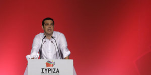 Porträt Alexis Tsipras vor einer roten Wand