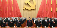 Chinas Parteiführer vor Hammer und Sichel und roten Fahnen