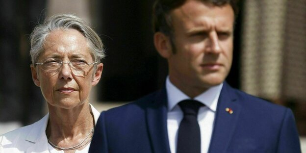 Premierministerin Elisabeth Borne geht hinter Emmanuel Macron