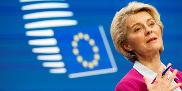 Ursula von der Leyen reckt das Kinn, im Hintergrund eine Europaflagge