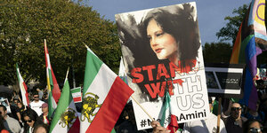 Protestierende mit iranischen Fahnen und dem Porträt von Mahsa Amini