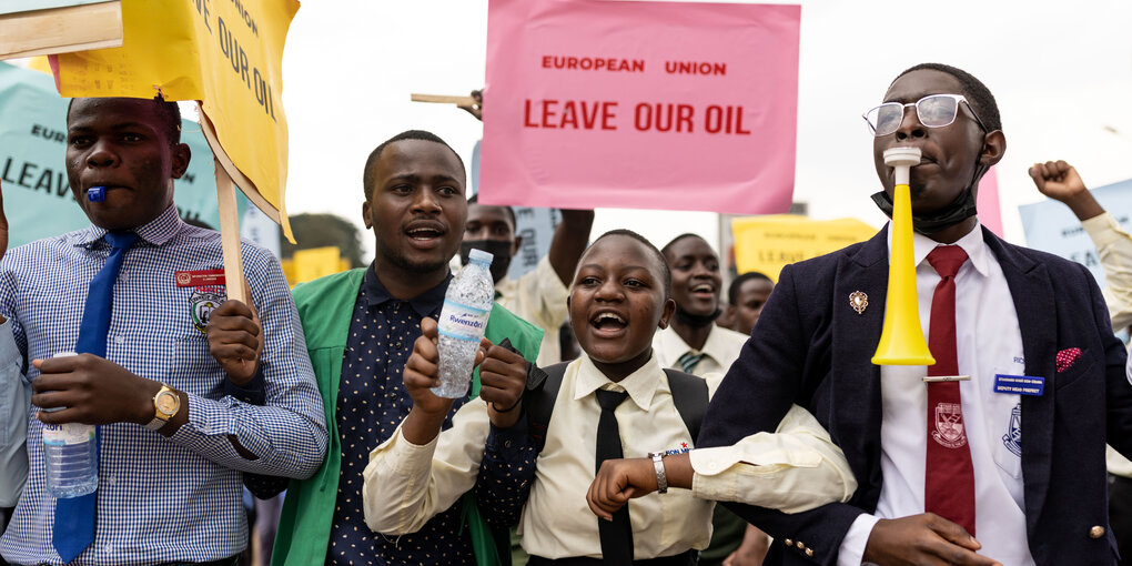 Junge Menschen protestieren ineinandergehakt, EUROPEAN UNION Leave our Oil steht auf einem rosa Protestplakat