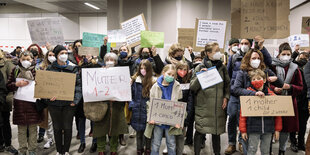 Menschen halten am Hauptbahnhof Schilder hoch, auf denen steht, wievielen Menschen sie Unterkunft gewähren können