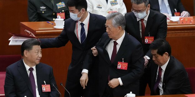 Xis Jinpings Vorgänger Hu Jintao, der grimmig blickt, wird aus der Großen Halle des Volkes geführt, weil es ihm angeblich schlecht ging