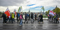 Demonstrierende laufen in Dresden über eine Brücke