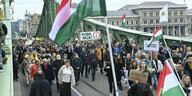 Protestierende Menge iauf der grünen Freiheitsbrücke in Budapest schwingt ungarische Fahnen
