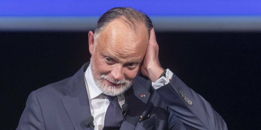 Edouard Philippe hält sich die Hand ans Ohr