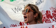 Demonstrantin mit Transparent voll roter Hände am Montag in Istanbul
