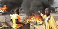 Ein aufgebrachter Mann vor einer brennenden Barrikade auf einer Strasse