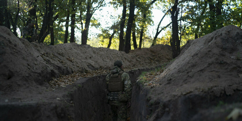 Ein ukrainischer Soldat überprüft die von russischen Soldaten ausgehobenen Schützengräben.