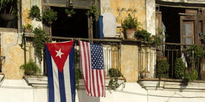 Die Flaggen Kubas und der USA hängen von einem Balkon