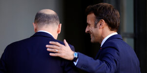 Macron legt seine Hand auf Scholz Schultern.