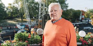 Hans Rosenau auf dem Balkon mit Baustelle hinter ihm