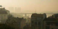 Smog in einer Stadt mit Hochhäusern und einer Brücke