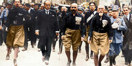 Historisches Foto: Mussolini im Anzug maschiert in Rom ein, neben ihm Männer in schwarzen Hemden