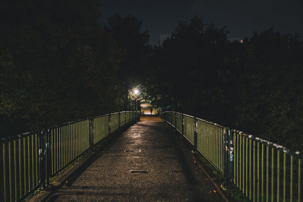 Eine leere Fußgängerbrücke im Dunkeln