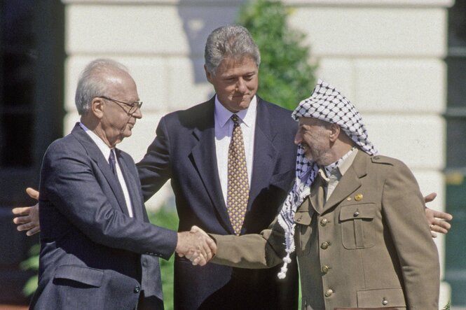 Bill Clinton zwischen Yitzhak Rabin und Yasser Arafat, die sich die Hand geben