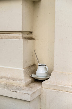 A cup and saucer is in a niche