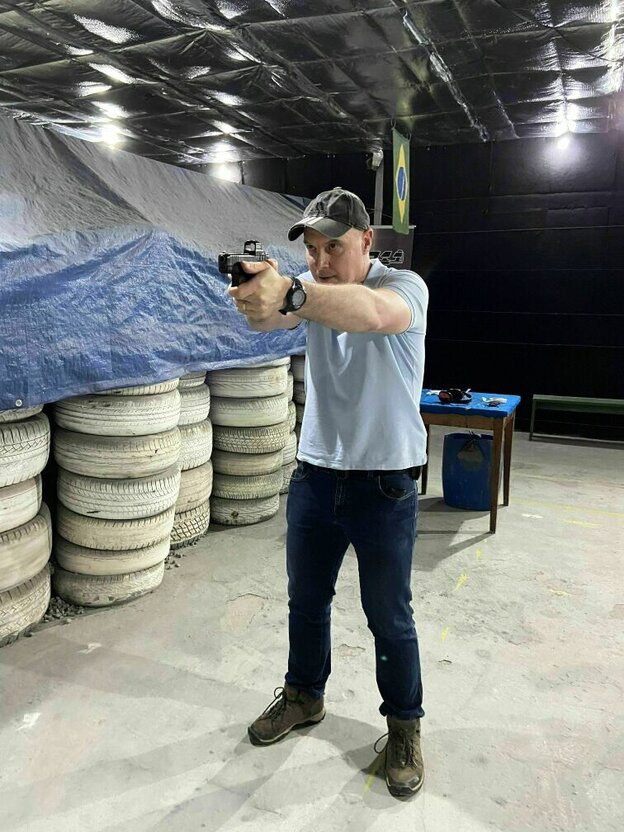 Ein Mann zielt mit gezogener Waffe auf Zielscheiben, die aber nicht im Bild zu sehen sind