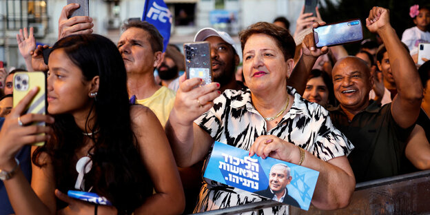 Anhänger und Anhängerinnen von Netanjahu halten Plakate mit dessen Gesicht in die Höhe