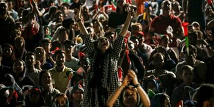 Fußballstadion in Teheran: Eine Frau steht und jubelt, viele Fans schauen sie wohlwollend an