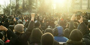 Zahlreiche Menschen protestieren und heben die Faust in die Höhe