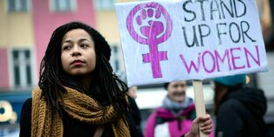 Eine Demonstrantin hält ein Schild mit der Aufschrift "Stand up for Women"