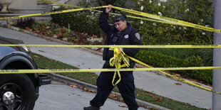 Eine Polizistin blockiert mit gelbem Absperrband die Straße unterhalb des Hauses von Paul Pelosi, dem Ehemann von Parlamentspräsidentin Nancy Pelosi, in San Francisco