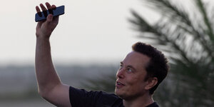 Elon Musk mit Handy in der Hand
