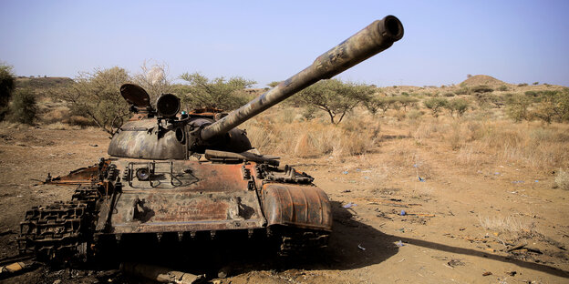 ein ausgebrannter Panzer steht in einer Wüste