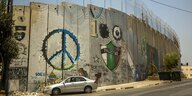 Auf die Mauer, die Betlehem von Ost-Jerusalem trennt, ist ein Peace-Zeichen gemalt
