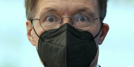 BundesGesundheitsminister Lauterbach mit fragendem Blick, er trägt eine schwarze Maske