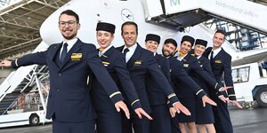 Kabinenpersonal der Lufthansa posiert vor einem Flugzeug