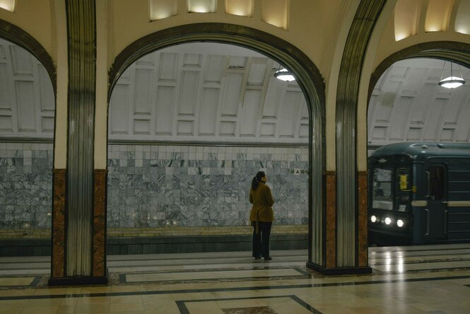 Eine Frau auf dem leeren Bahnsteig eines U-Bahnhofs