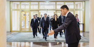 Annalena Baerbock mit einer Delegation im Foyer eines Gebäudes