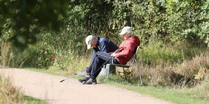 Ein Rentner und eine Rentnerin auf einer Parkbank