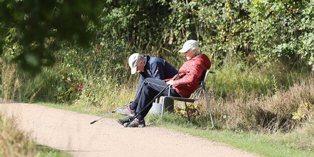 Ein Rentner und eine Rentnerin auf einer Parkbank